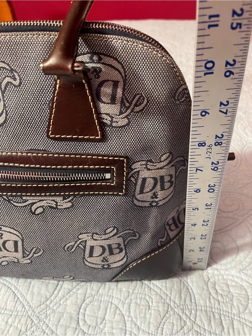 Dooney and Bourke Monogram Denim Donegal Dome Satchel with brown leather trim.